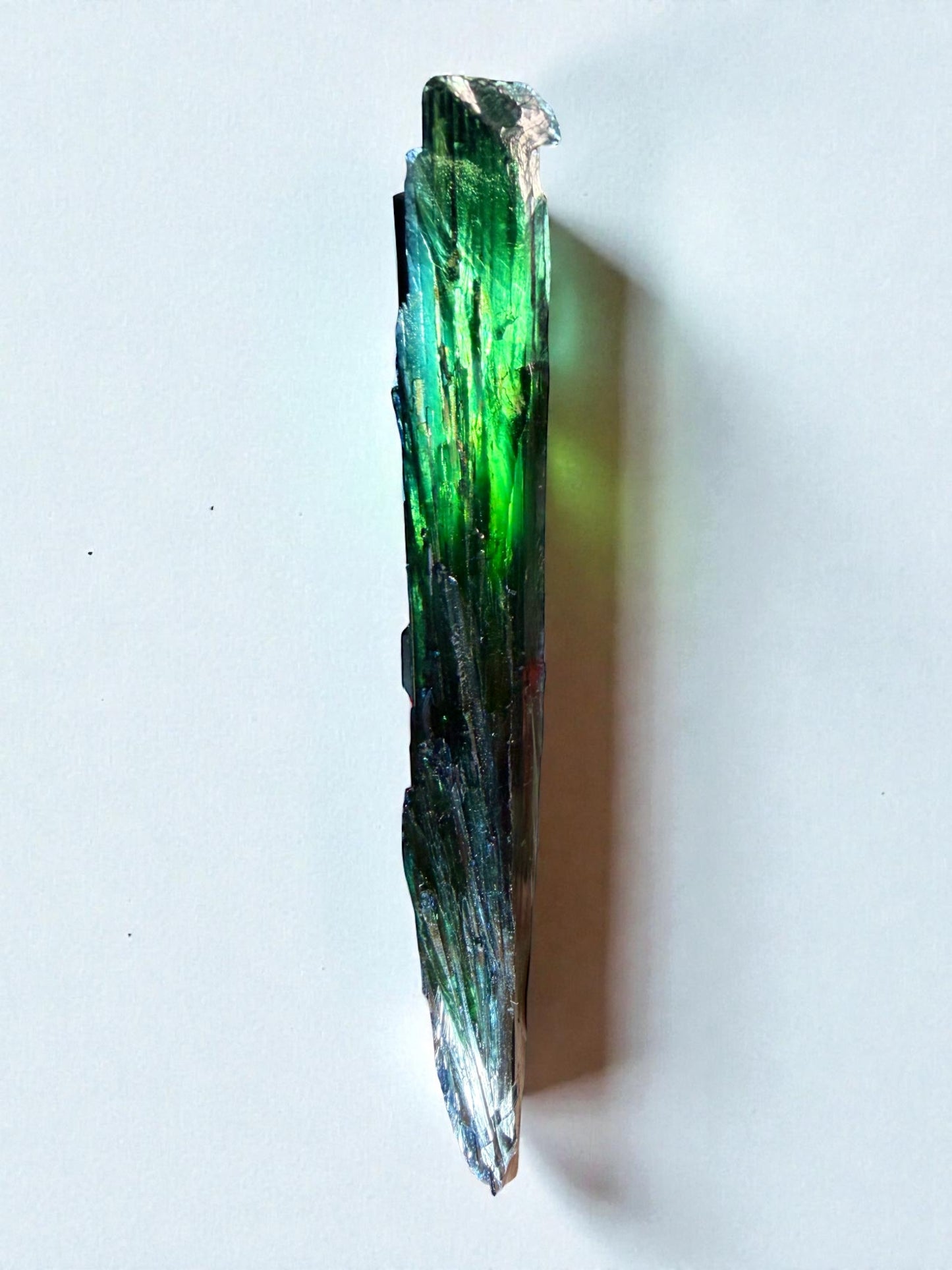 Side view of elongated vivianite cluster showing bent terminations and internal green glow.