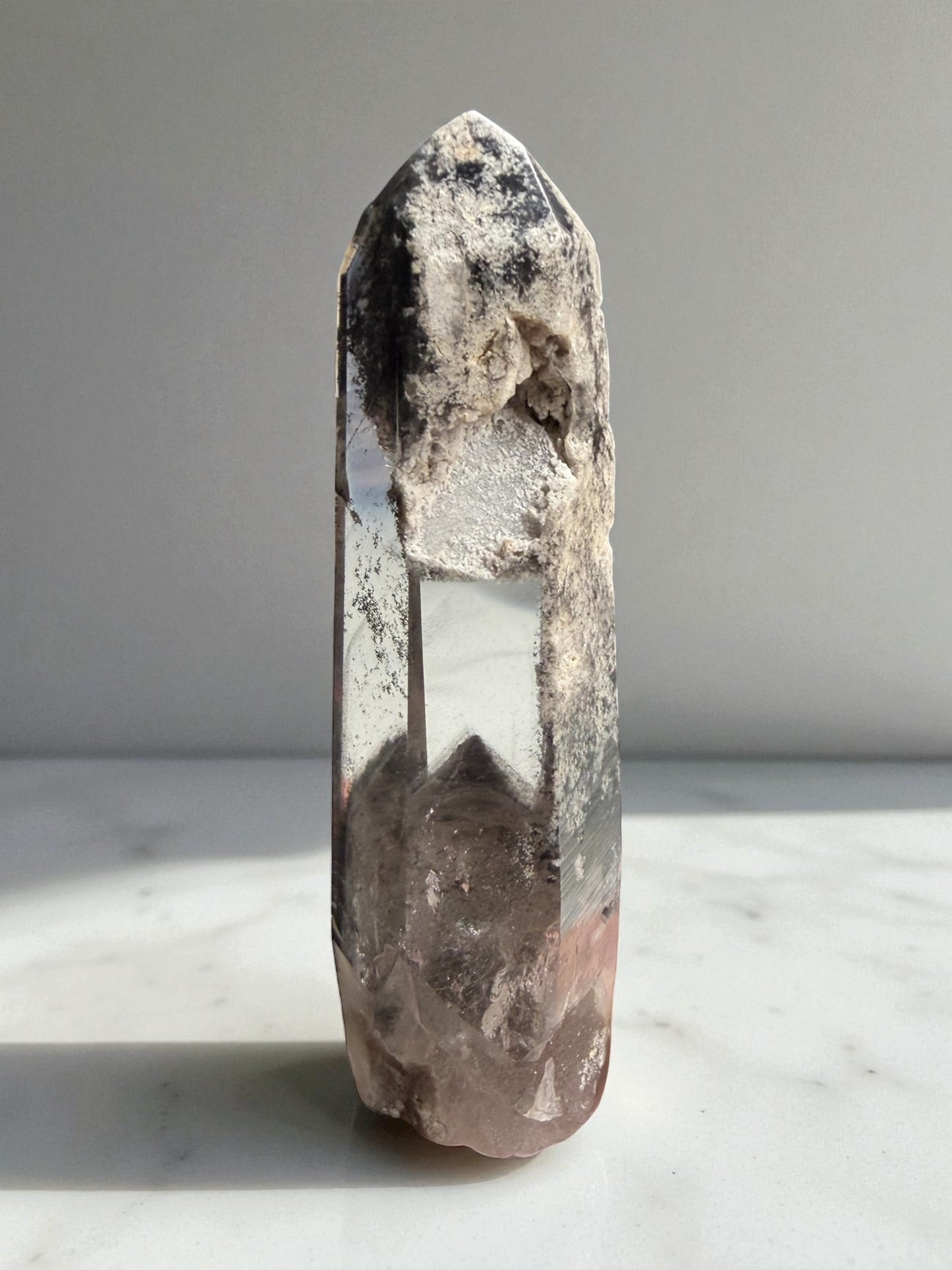 Garden quartz point from Brazil featuring a black phantom and natural inclusions.